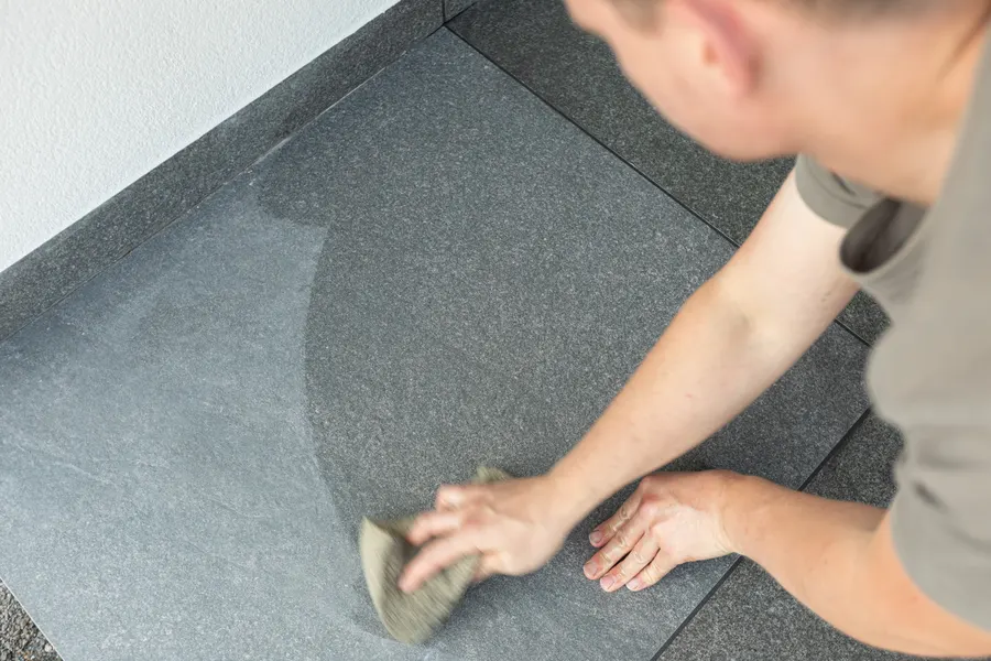 Fliesenleger von Linnemeier trägt eine Abdichtung auf einer Terrasse auf