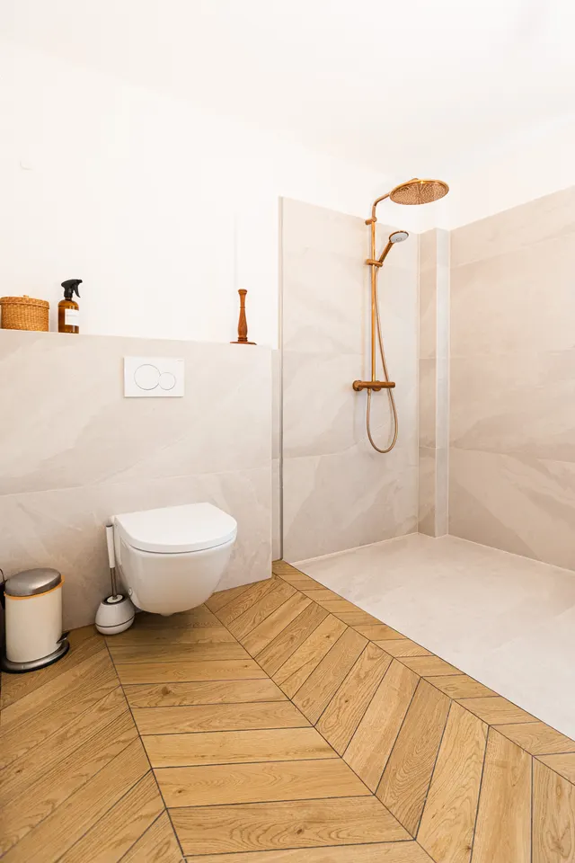 Bodengleiche Walk-in-Dusche mit Übergang zum Fischgrätboden in Holzoptik