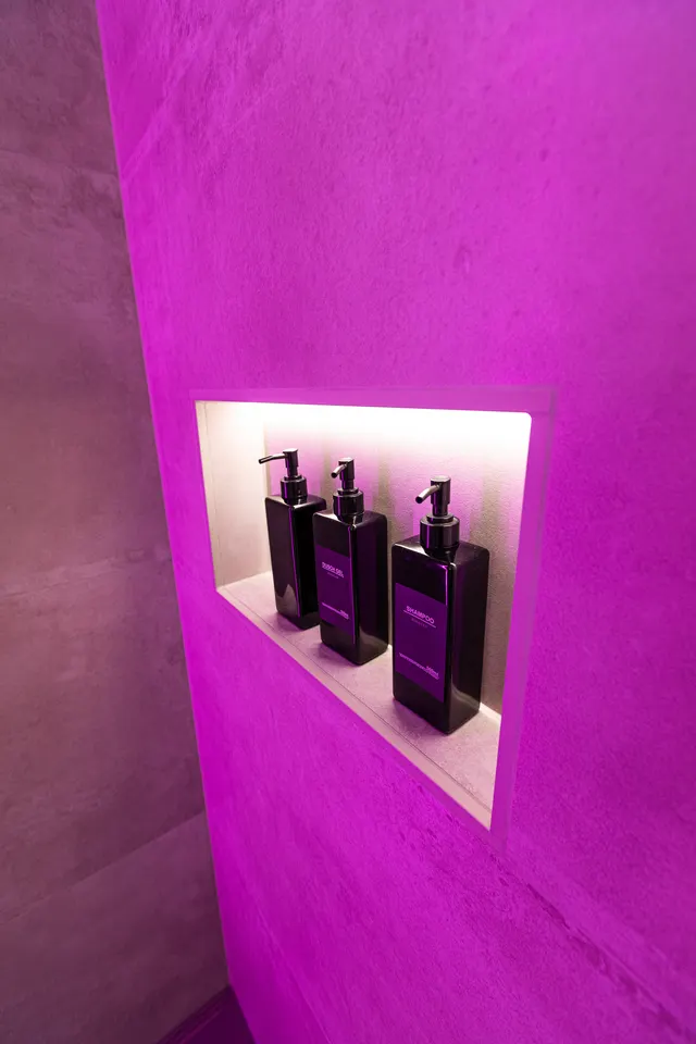 Nische mit farbigem LED-Licht und schwarzen Spendern
